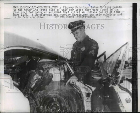 1960 Press Photo Highway Patrolman Laten Mullins points to motor and front tire - Historic Images