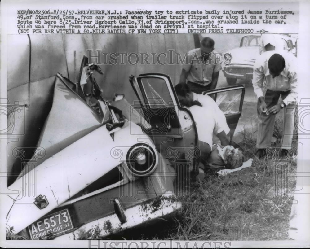 1957 Press Photo Passerby try to remove injured James Burriesce from crushed car - Historic Images