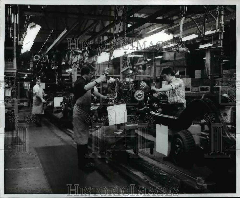 1979 Press Photo Assembly line works on chassis preparation at auto plant - Historic Images