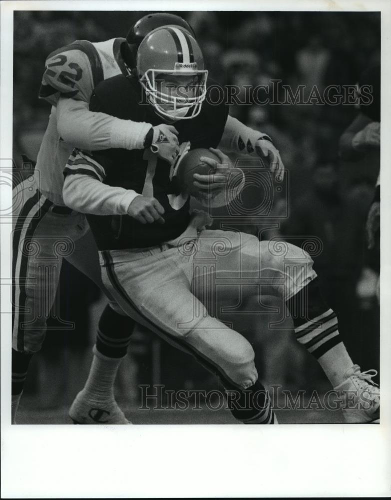 1990 Press Photo Bernie Kosar is tackled by Vince Newsome in the 4th quarter. - Historic Images