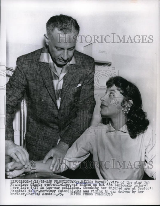 1958 Press Photo Dr. Mortimer Weiss checks arm of Willie Mays' wife after crash - Historic Images