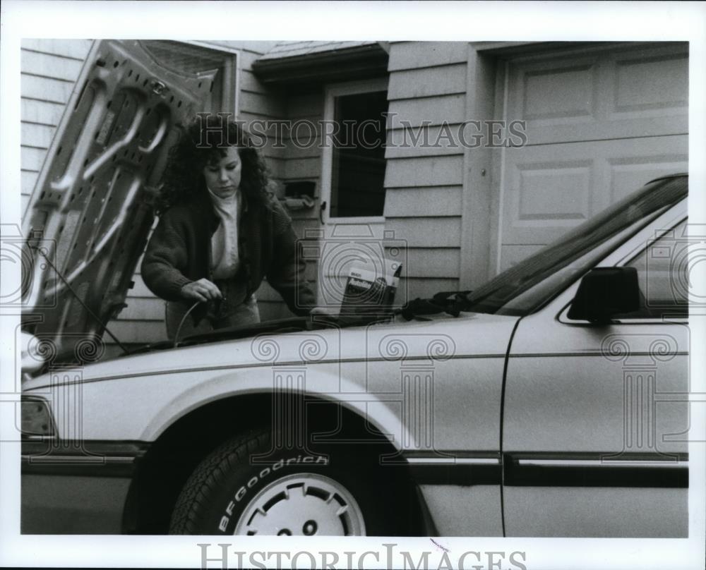 1990 Press Photo A woman shown repairing her vehicle. - spp01645 - Historic Images