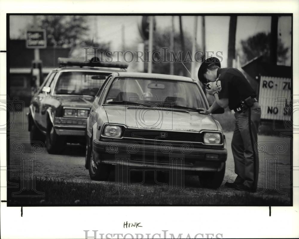 1991 Press Photo Sgt. Steven Nagy checks car at Bennett&#39;s Corners in Hinckley - Historic Images