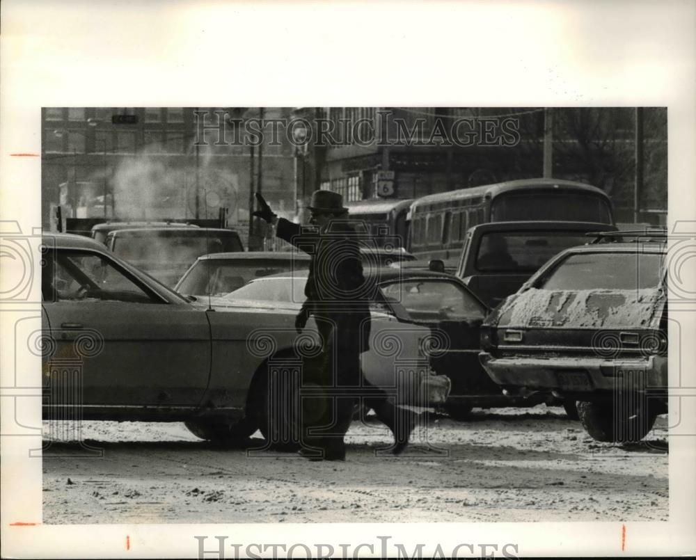 1977 Press Photo Jack O&#39;Donnell stops to direct traffic at 9th and Superior - Historic Images