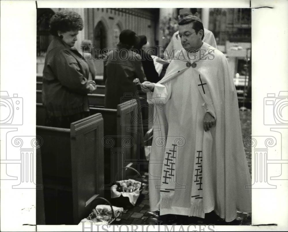 1989 Press Photo Bishop Anthony Pilla blesses Easter food basket during ceremony - Historic Images