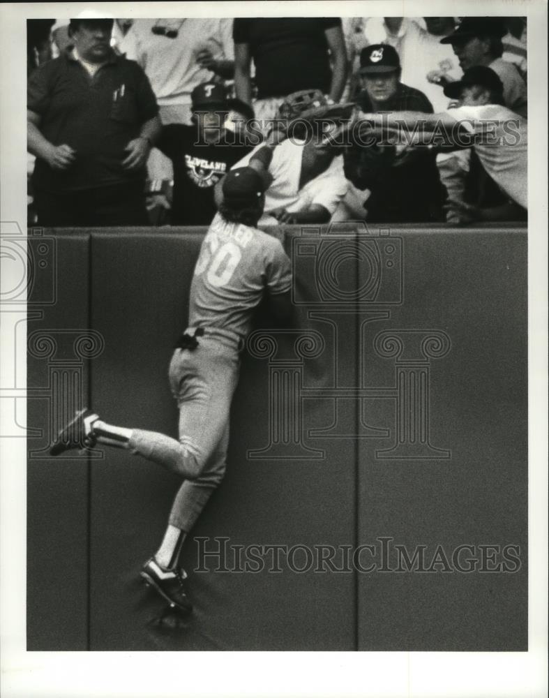 1989 Press Photo Pat Tabler climbs the right field wall in pursuit of a home run - Historic Images
