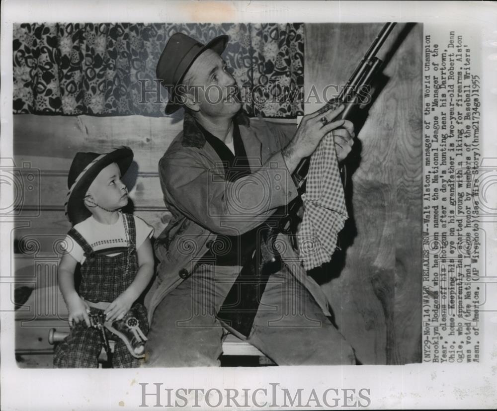 1955 Wire Photo Walt Alston cleaning his shotgun while his grandson watches - Historic Images