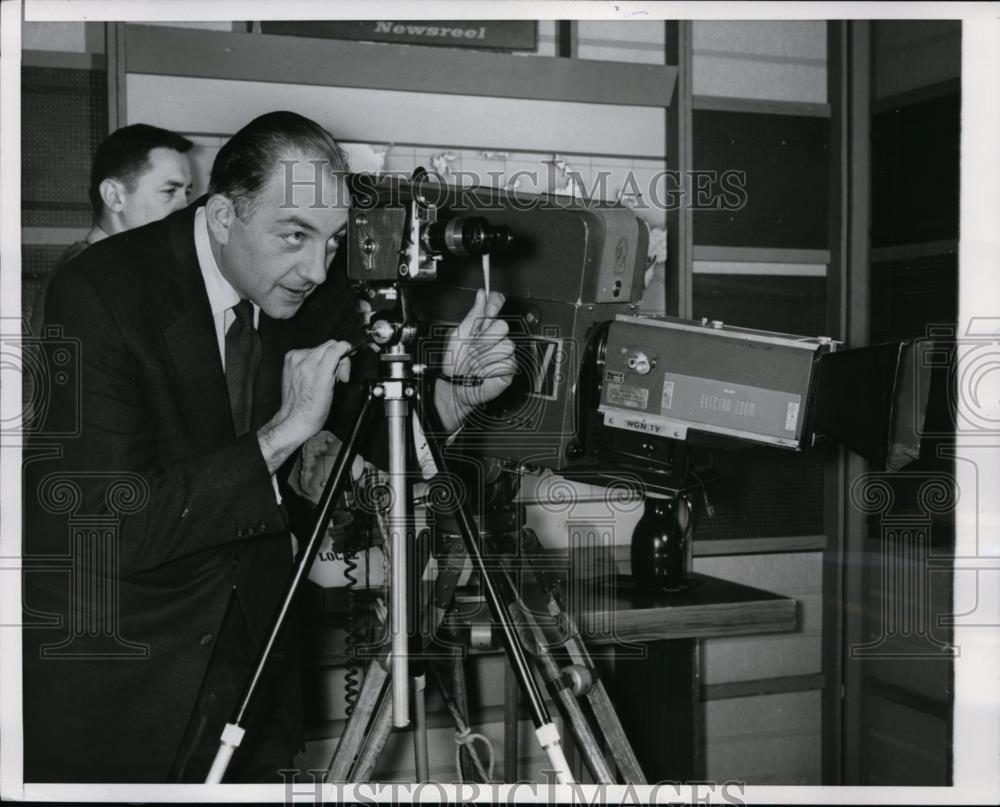 1956 Press Photo Spencer Allen, TV announcer, inspects 8mm home movie camera - Historic Images