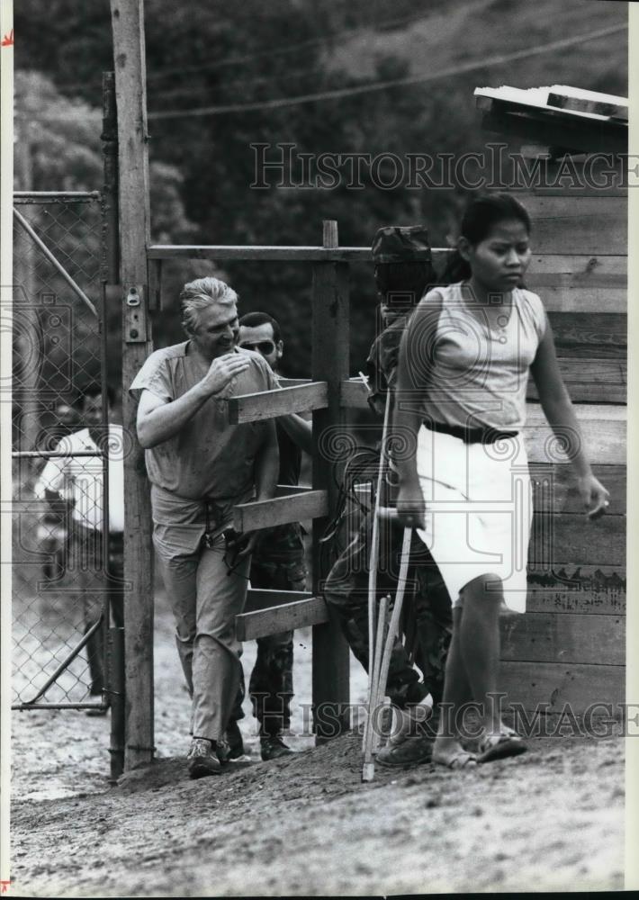 1990 Press Photo Liposky enters the medical compound through a wooden turnstile - Historic Images