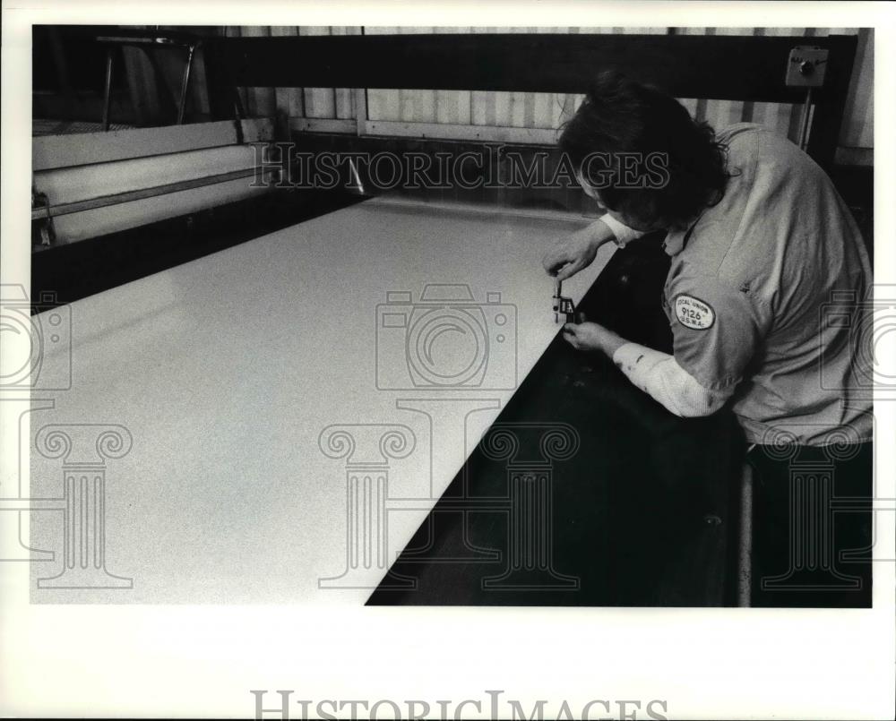 1991 Press Photo Inspector Jim Binder checks gauging on roll of steel - Historic Images