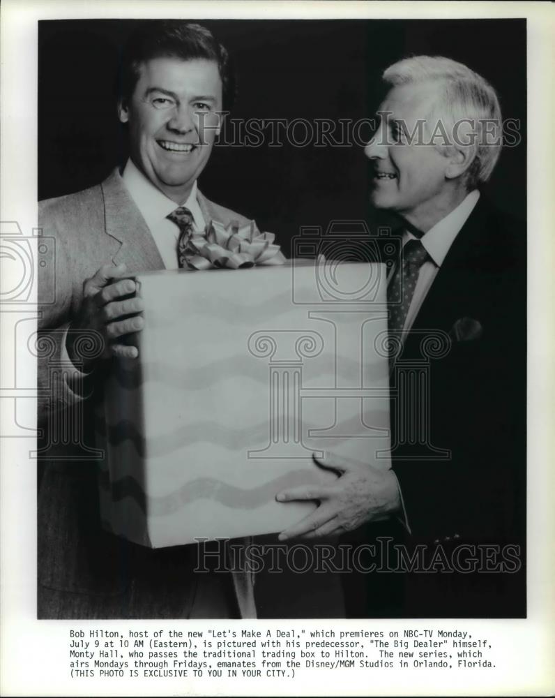 Press Photo Monty Hall passes box to Bob Hilton, host of Let&#39;s Make A Deal - Historic Images