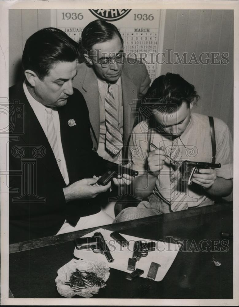 1936 Press Photo Clarence Larkin inspecting guns with Bureau of Identification - Historic Images