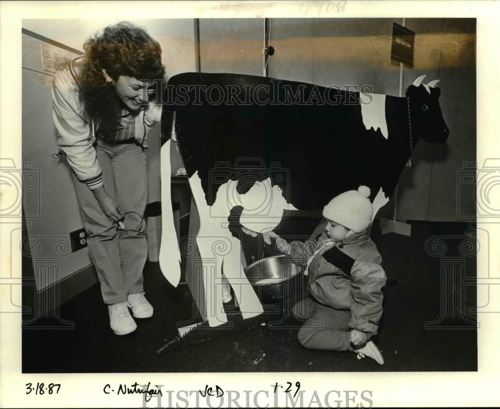 1987 Press Photo Sarah Koehler milks plywood cow at children's health fair - Historic Images