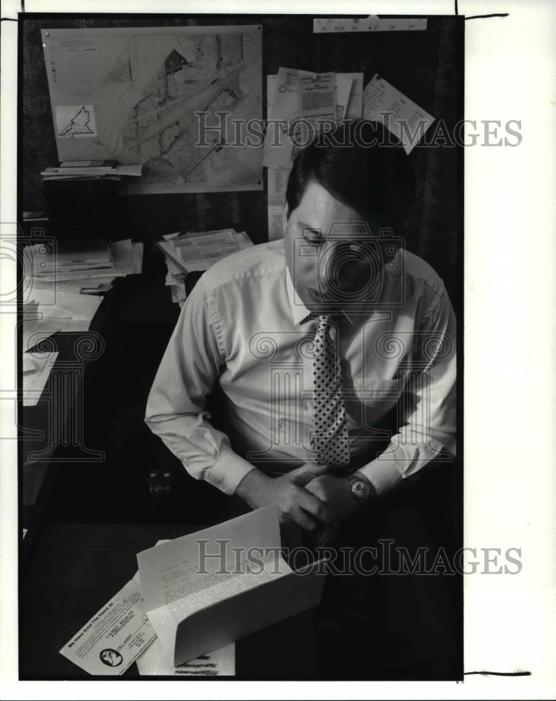 1989 Press Photo Mike Polensek reads a letter and postcard from realty companies - Historic Images