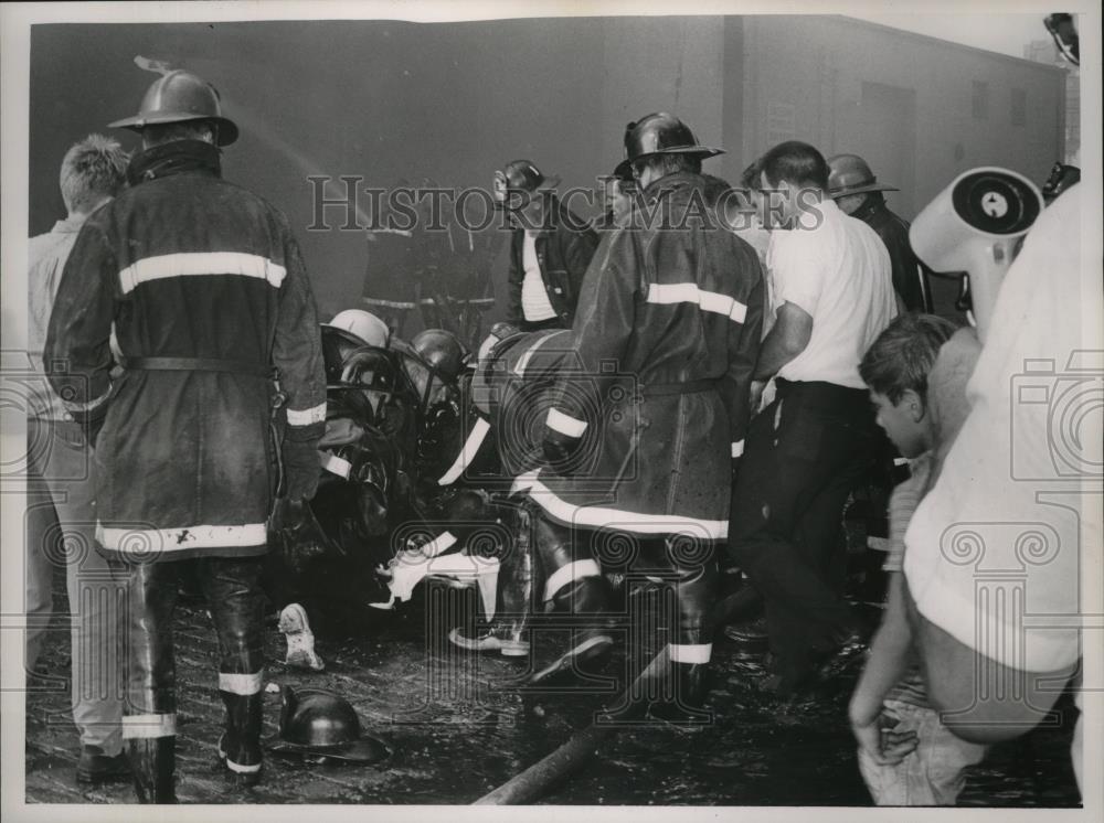 1966 Press Photo Fireman being placed on a stretcher at the scene of a fire. - Historic Images