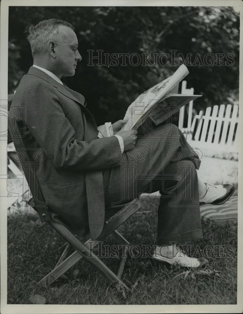 1936 Press Photo Man reads newspaper outside in lawn chair - nef61059 - Historic Images