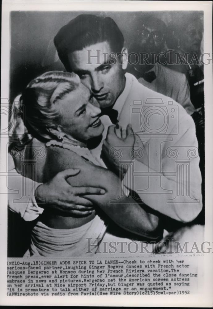 1952 Wire Photo Cheek to cheek with her serious-faced partner, laughing Ginger - Historic Images