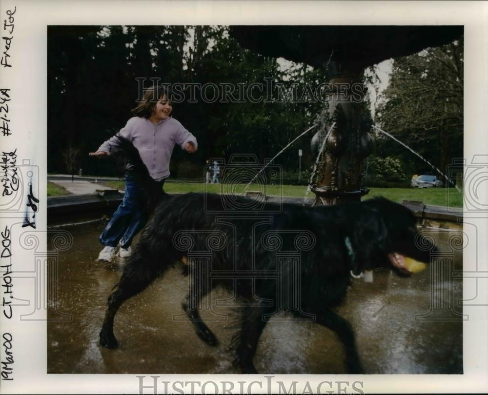 2000 Press Photo Unidentified kid playing w/ her dog in the park at spring time - Historic Images