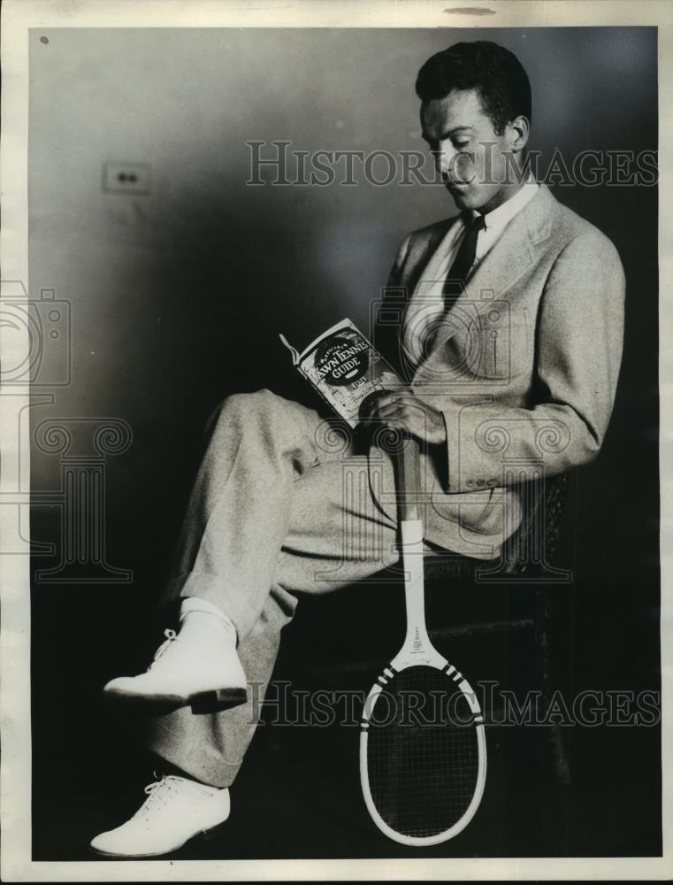 1934 Press Photo Ralph Minnick, tennis player, reading Lawn Tennis Guide book - Historic Images