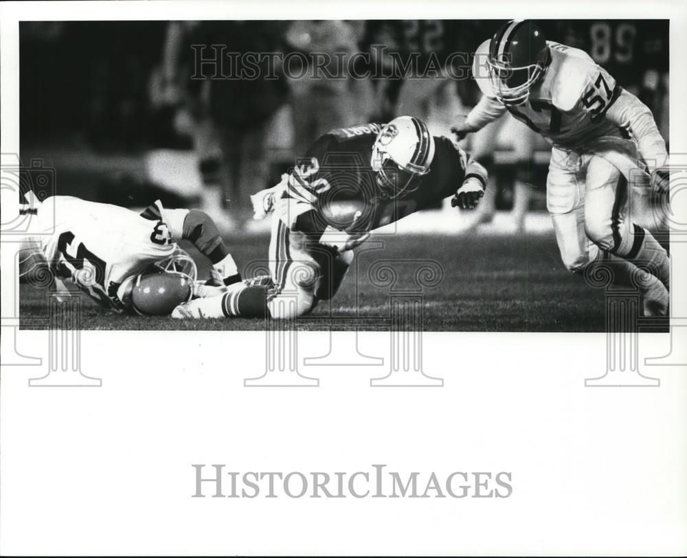 1986 Press Photo Anthony Griggs, Browns, stops Ron Davenport, Dolphins, football - Historic Images