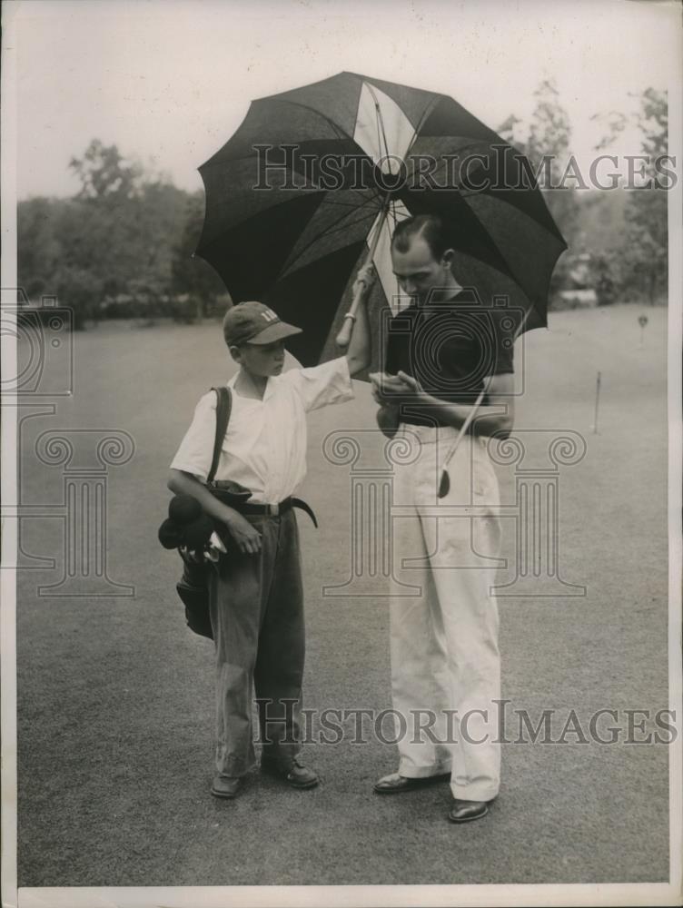 1936 Press Photo Golfer Al Priebe records his score as caddy holds an umbrella - Historic Images