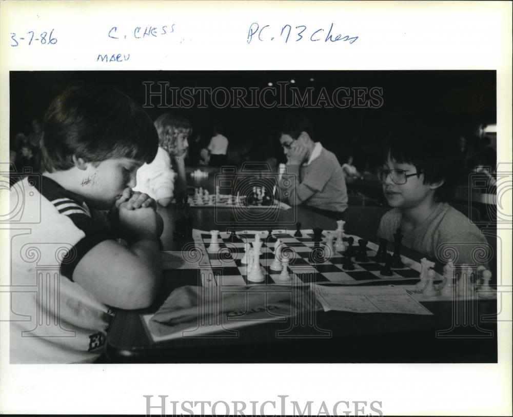 1986 Press Photo Alan Woodward studies board during game with Chris Lim - Historic Images