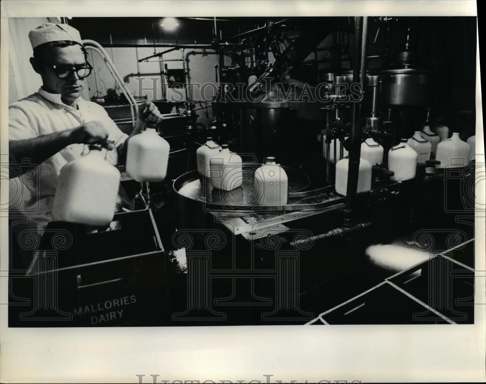 1975 Press Photo Louis Leon Smells Gallon  Milk Jugs  - orb11219 - Historic Images