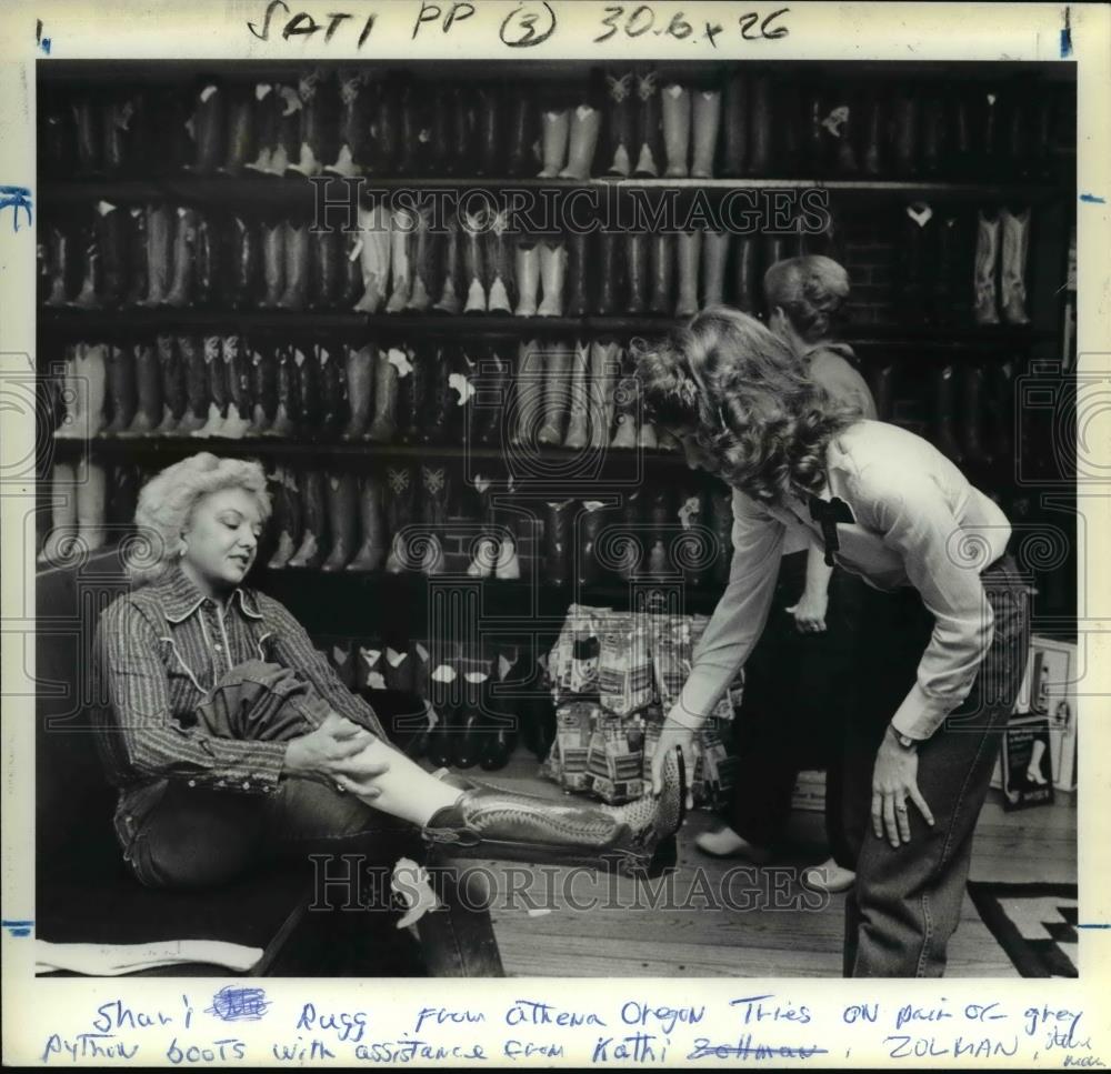Press Photo Shari Rugg Of Athena Tries On Boots With Kathi Zolman, Manager - Historic Images