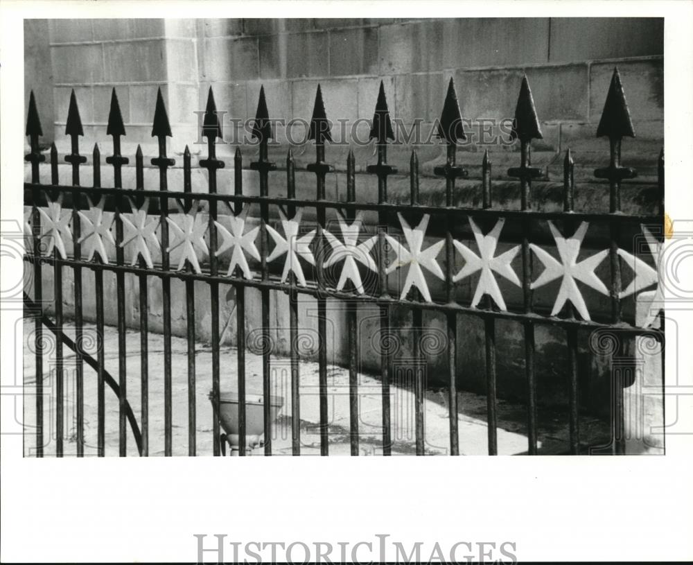 1987 Press Photo A fence of eight-pointed Maltese crosses surrounds a building - Historic Images