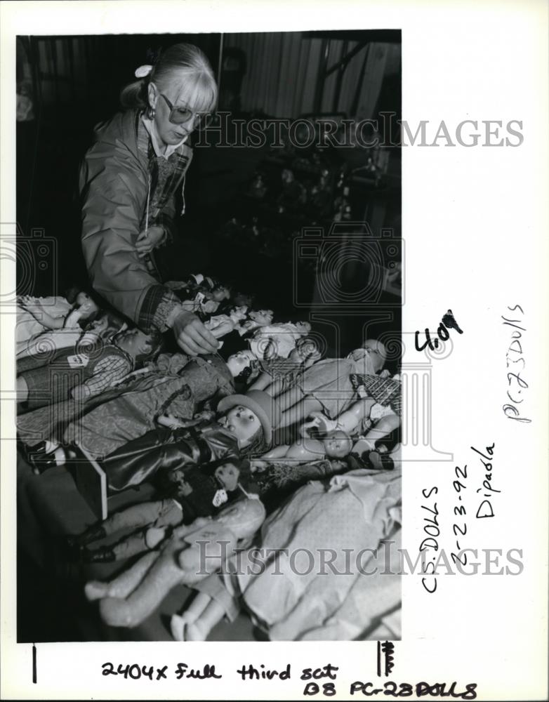 1992 Press Photo Pam Martin, a doll collector, examines a thousands of dolls - Historic Images