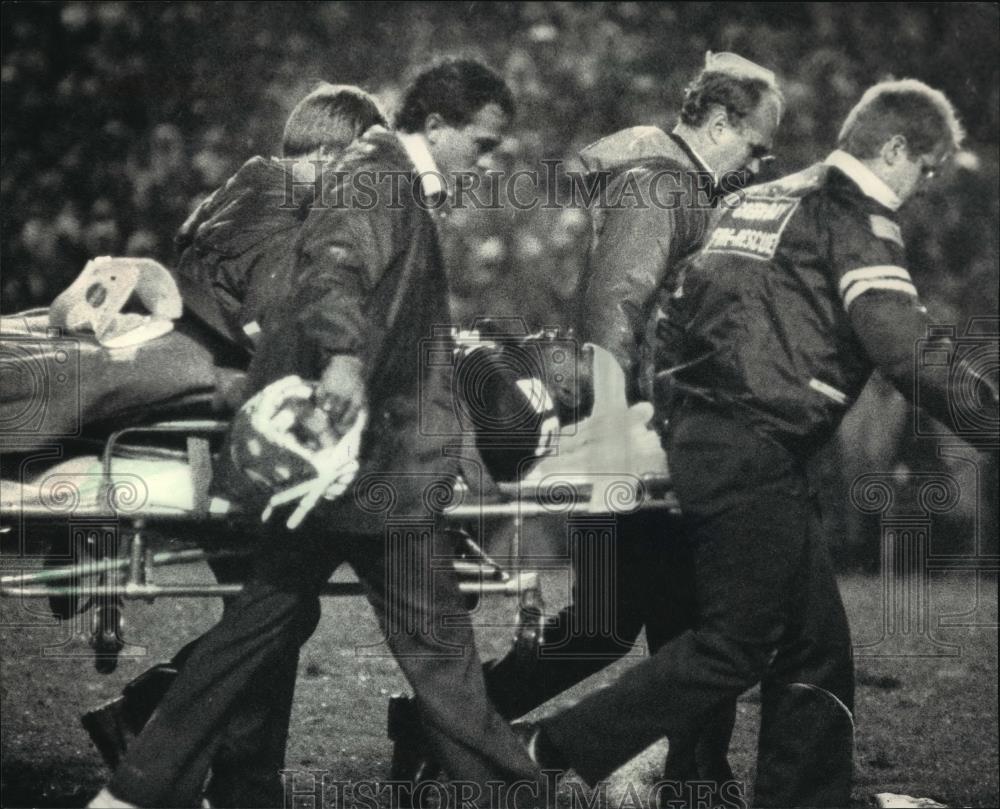 1986 Press Photo Packer Tim Lewis Carried Off Lambeau Field On a Stretcher - Historic Images