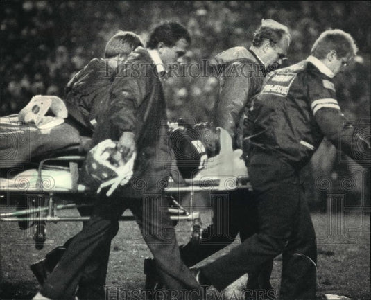 1986 Press Photo Packer Tim Lewis Carried Off Lambeau Field On a Stretcher - Historic Images