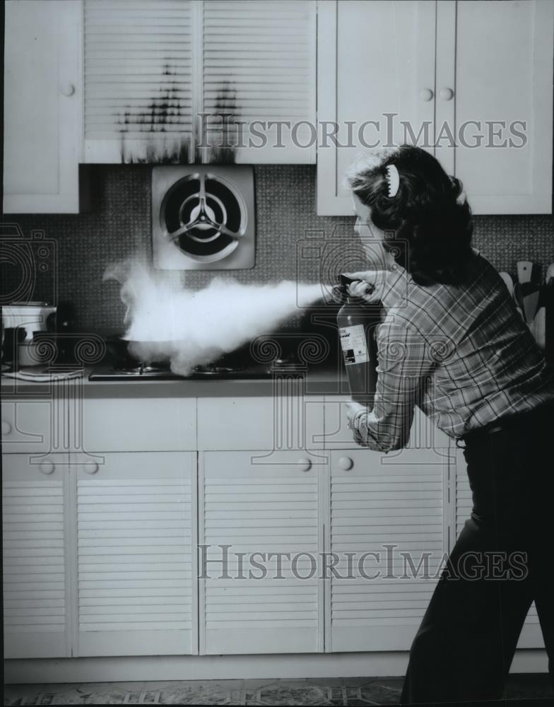 Press Photo Women spraying fire extinguisher in home. - spa51459 - Historic Images