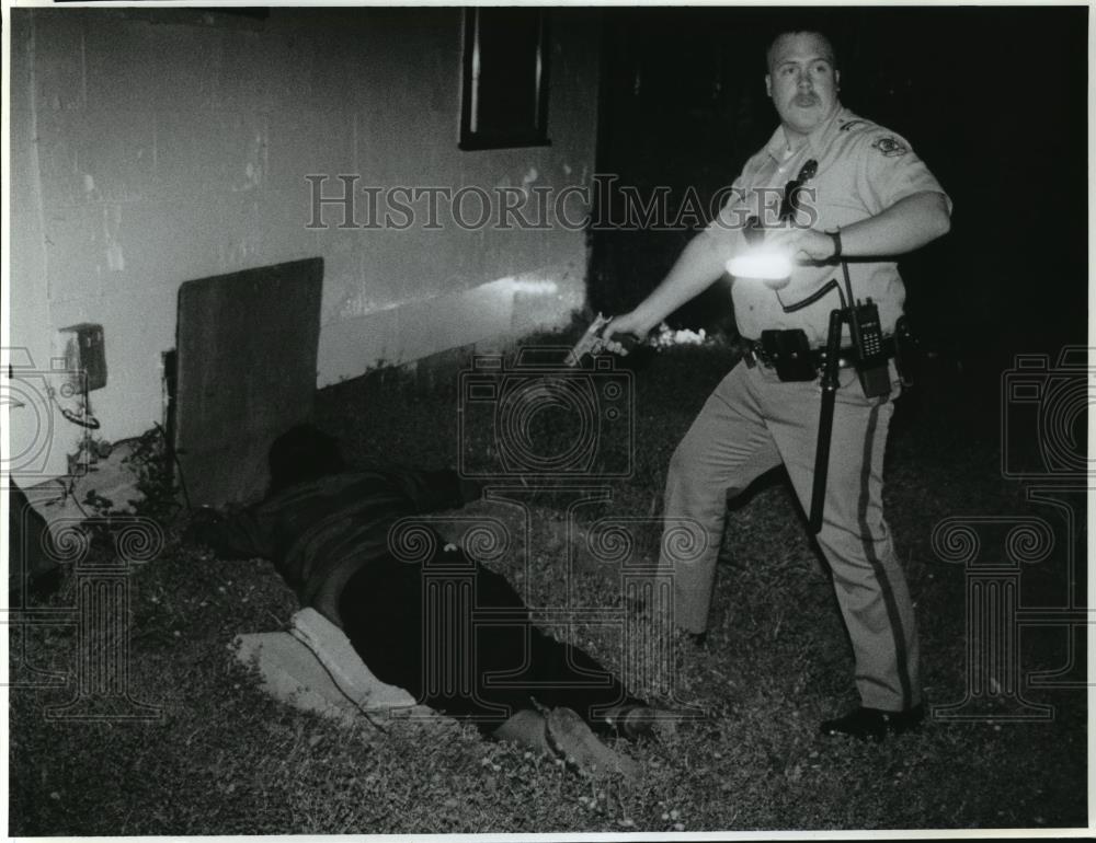 1993 Press Photo Officer Brent Melander detains suspected dealer after raid. - Historic Images