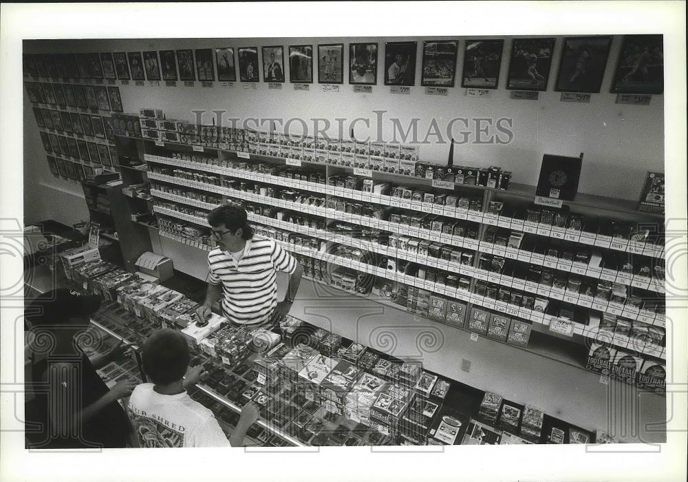 1994 Press Photo Sports cards store owner, Chuck Gaylord, attend to customers - Historic Images
