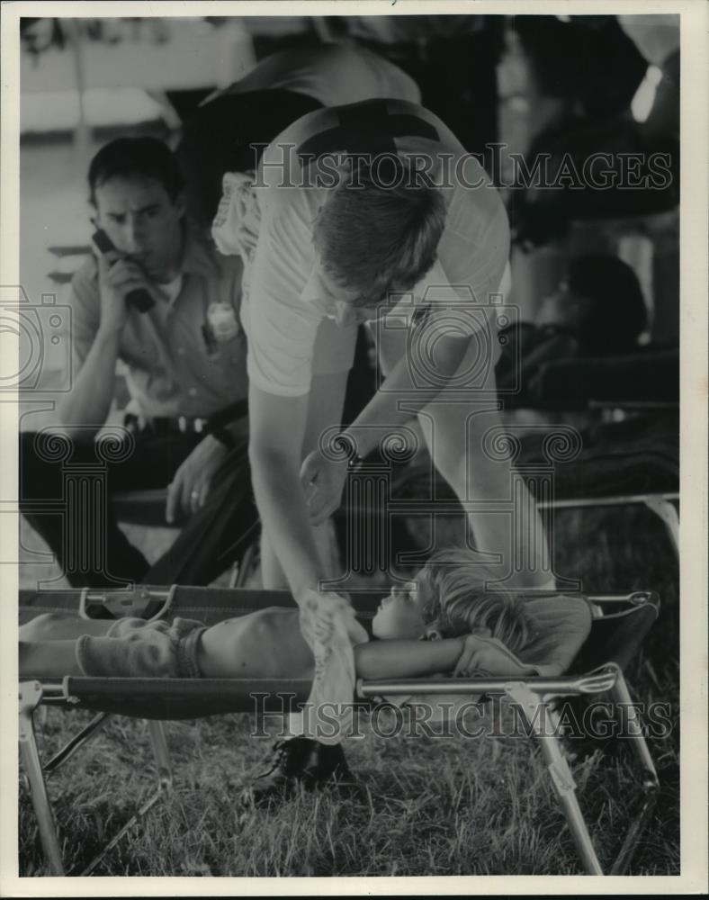 1985 Press Photo Volunteer Uses Damp Cloth to Cool Down a Young Boy in Milwaukee - Historic Images