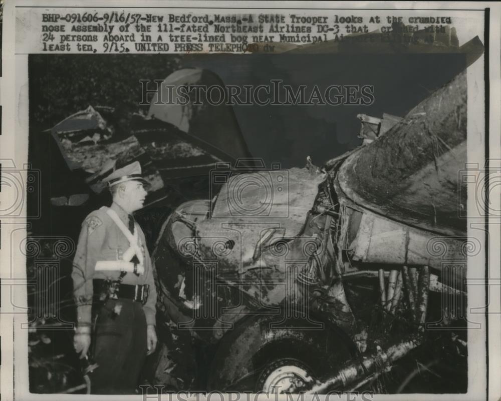 1957 Press Photo Bedford MA State trooper looks at NE Airlines crash wreckage - Historic Images