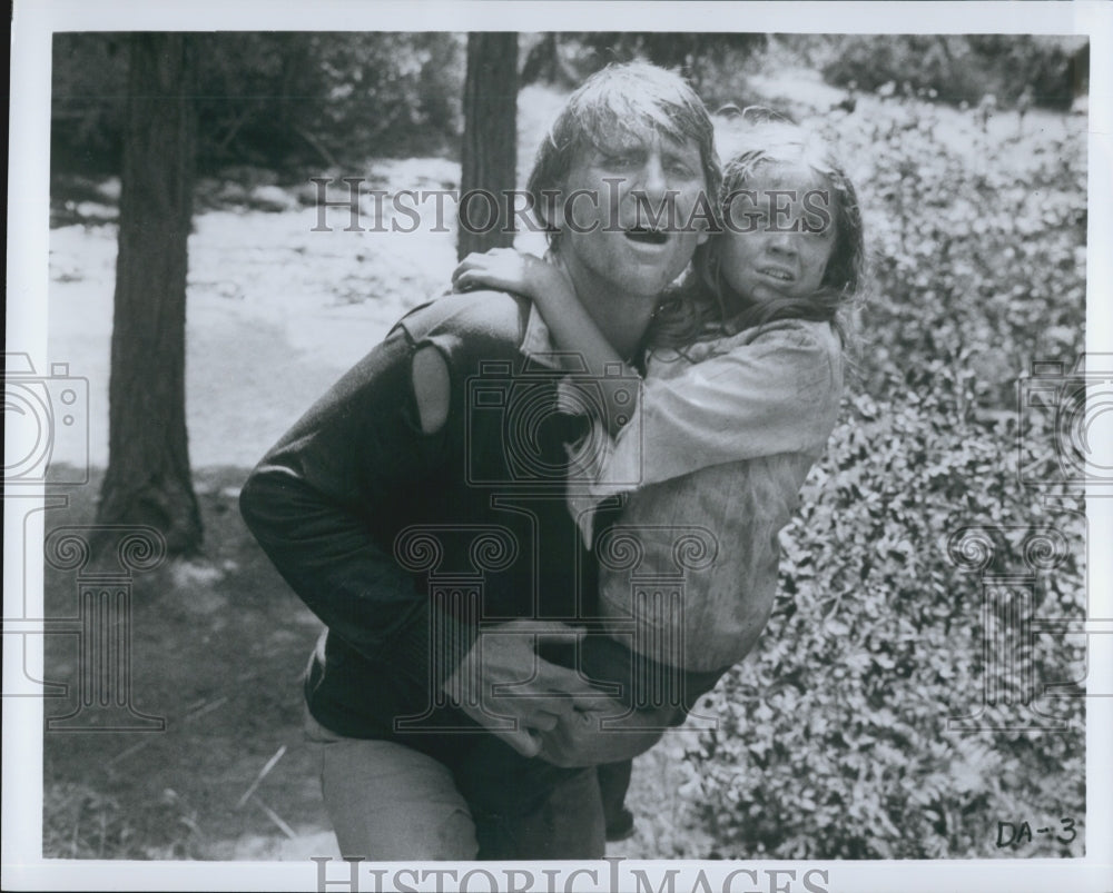 Press Photo Actor Carrying Young Actress in Rough Terrain - Historic Images