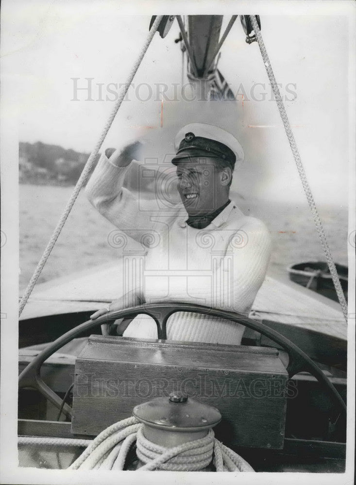 1958  Lt. Comm. Graham Mann at the helm of yacht - Historic Images