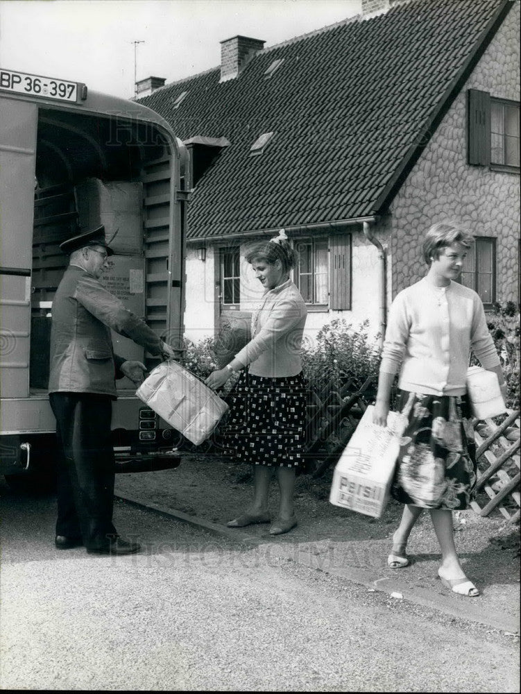  Girls carrying supplies off delivery truck - Historic Images