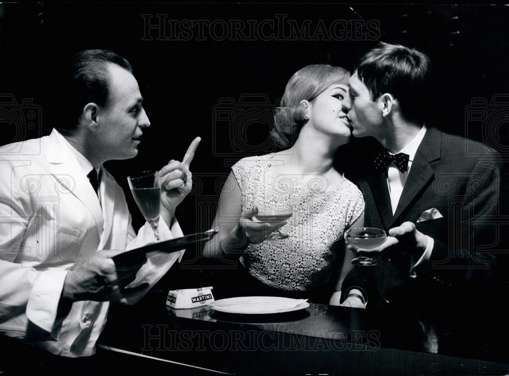 1965, Couple kissing in front of waiter - KSB27385 - Historic Images