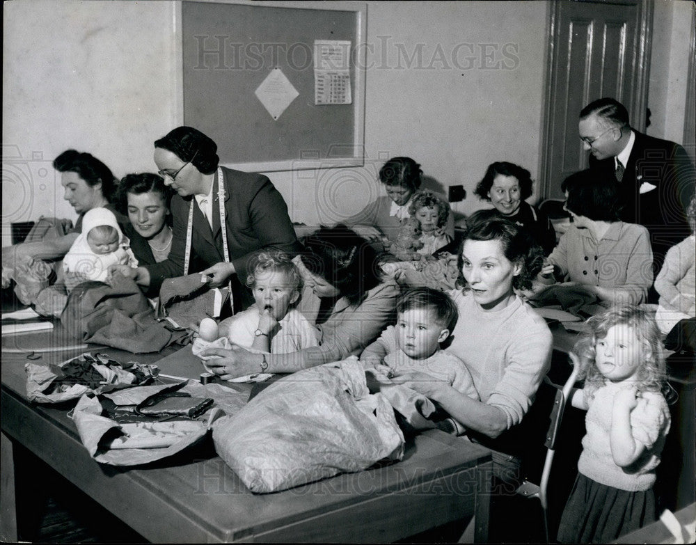 Press Photo Babies Sit With Their Mothers During Dress-making Class - KSB27963 - Historic Images