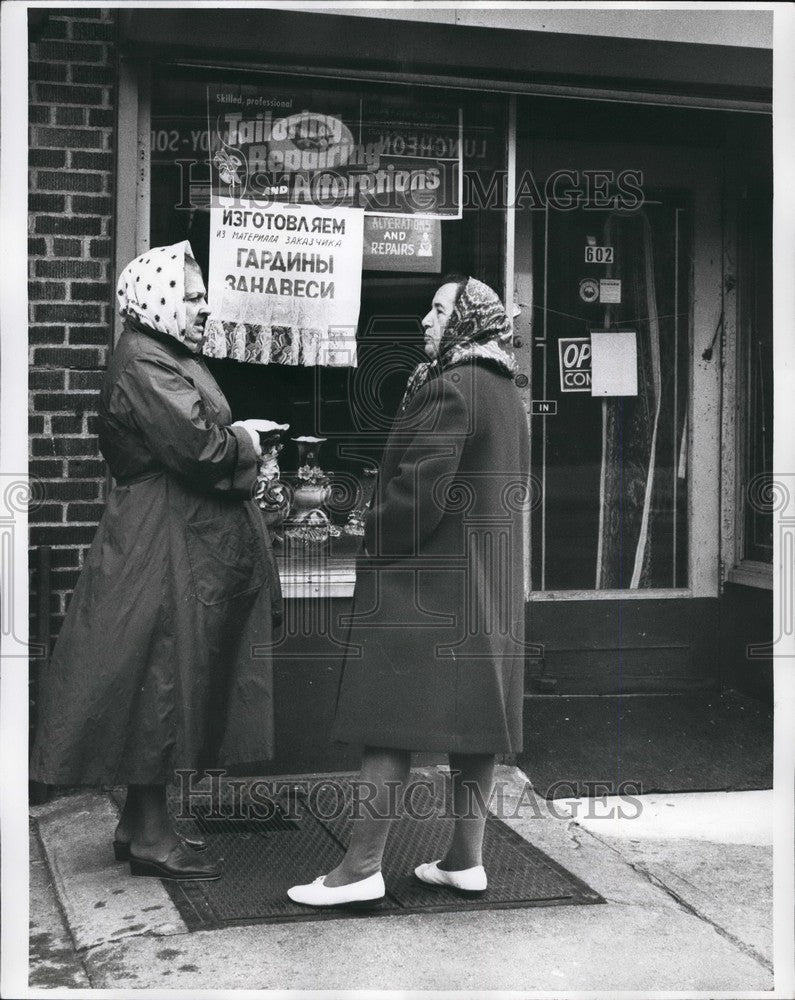 Press Photo older woman converse in front of business for tailoring - KSB55457-Historic Images