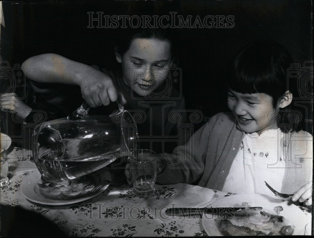 Press Photo A Lady Pours A Drink For A Child - KSB61267 - Historic Images