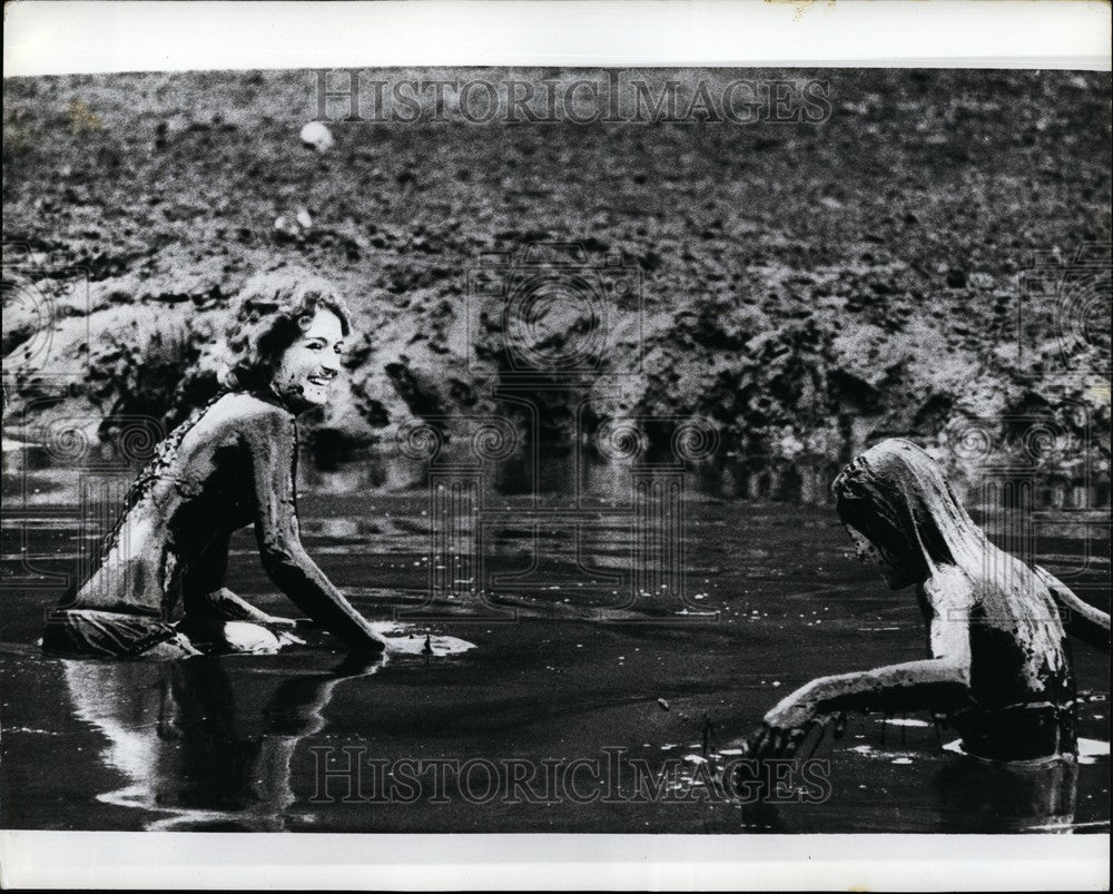 1973 Two girls, with skin glistening with mud in Australia, - Historic Images