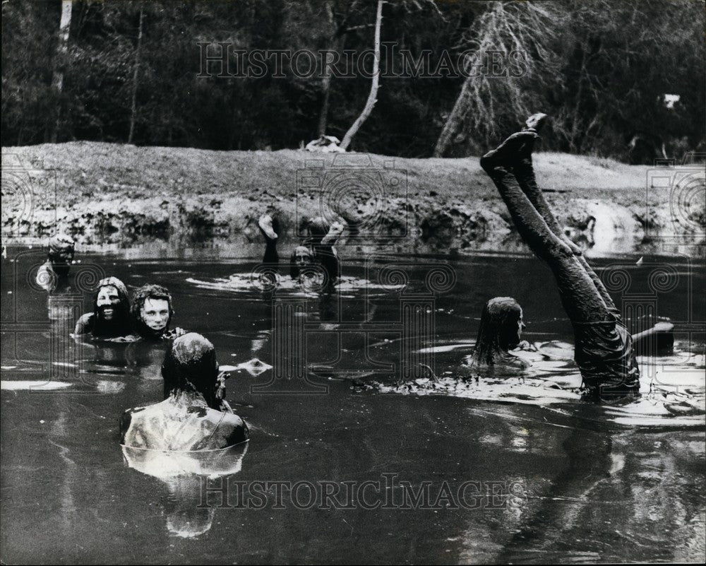 1973 The locals from down under get head over heals in the mud. - Historic Images