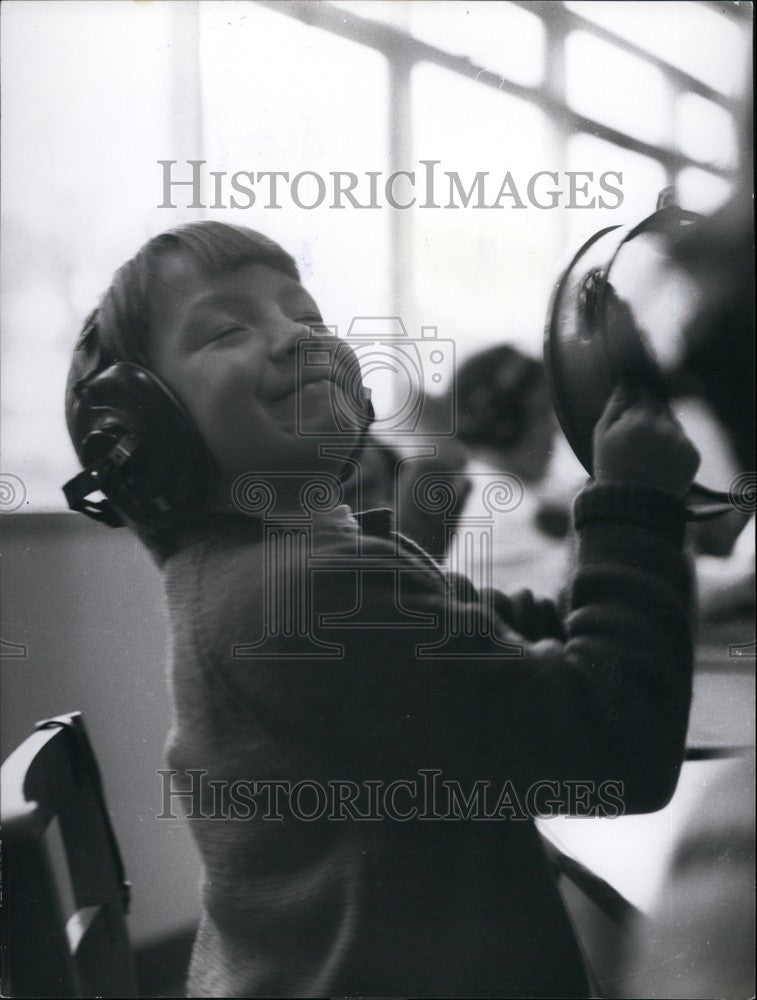 Press Photo Girl Listening To Music With Ear Phones Playing Tambourine - Historic Images