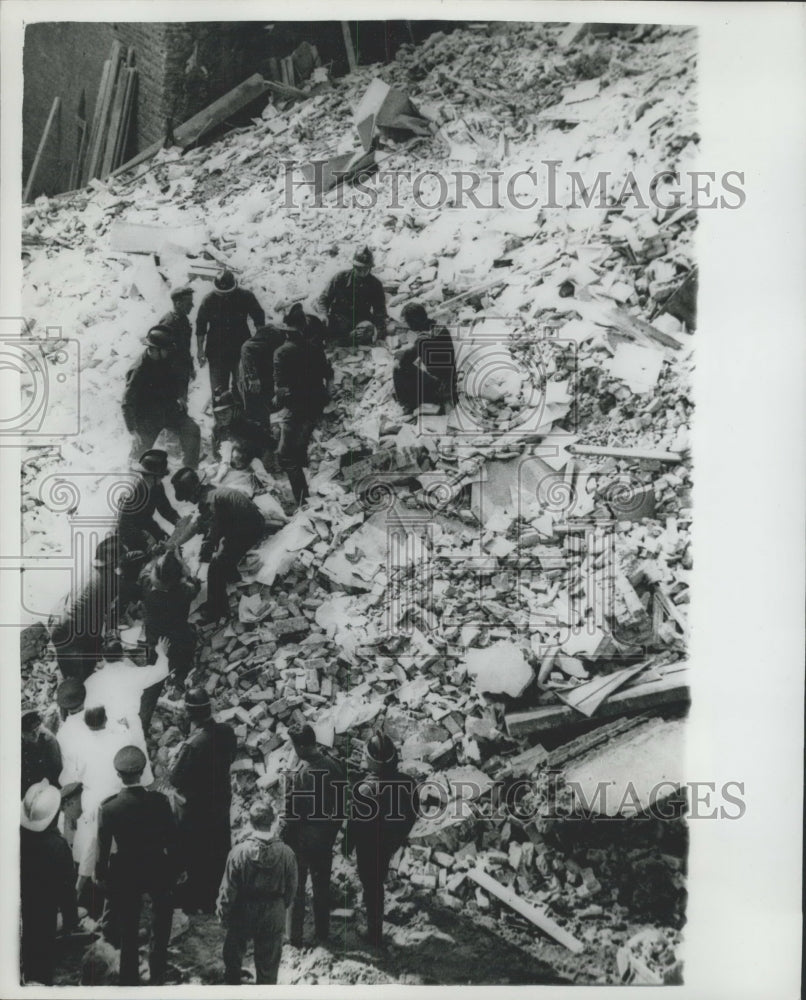 1962 Firemen take a woman from the wreckage of collapsed bldg - Historic Images