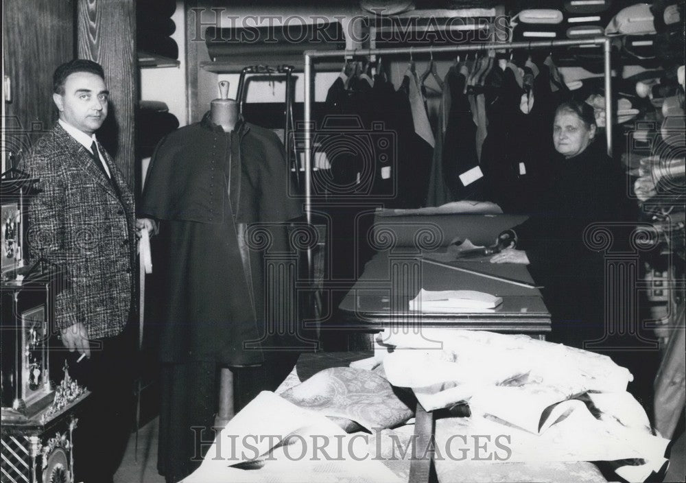 Press Photo Tailor measures up an unfinished robe - Historic Images