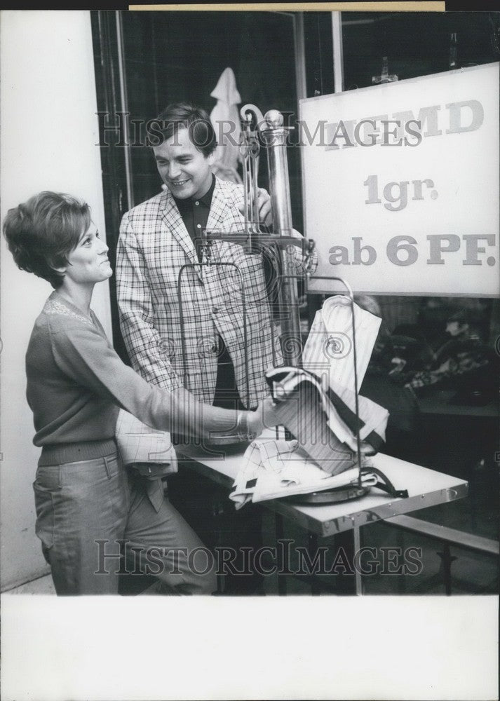 1967 Attractive saleswoman brings men to "gimmicky" store in Berlin. - Historic Images